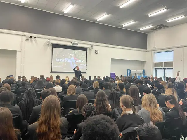 Students seated in a school hall during a presentation