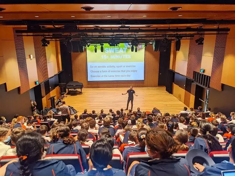 A full school auditorium during a Simple Six presentation